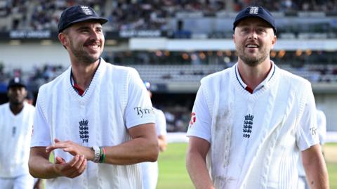 Josh Tongue and Ollie Robinson smile as they walk off the field together