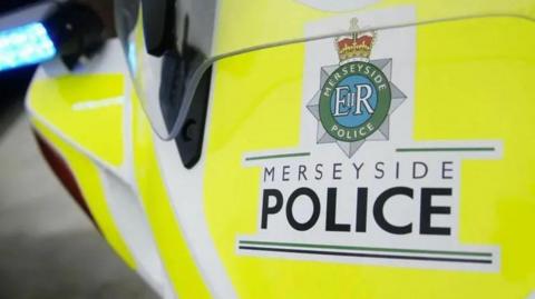 A close-up image of the Merseyside Police logo on the side of a police car.
