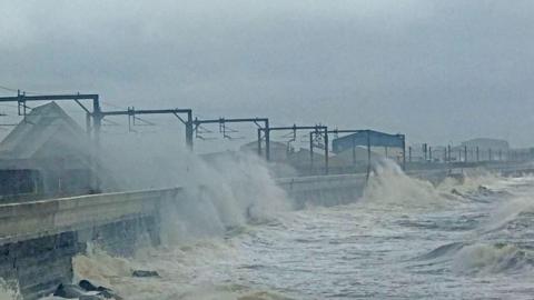 Waves crash up the sea wall, sending spray over the railway line at Saltcoats in Ayrshire