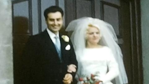 A bride and groom standing in front of doors 