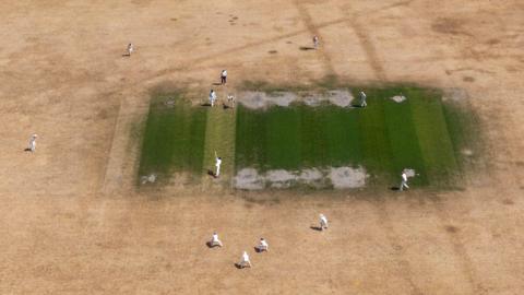 Cricketers play on parched ground in Bray