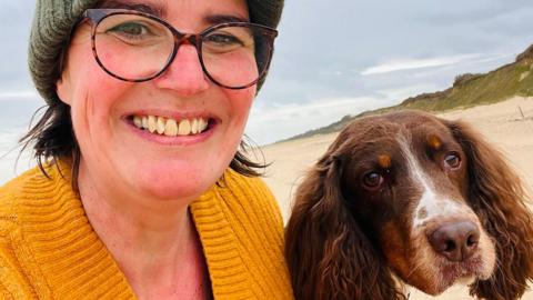 A woman and a dog on a beach
