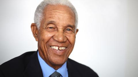 Garfield Sobers in a recent pic wears a suit smiling