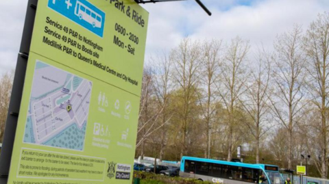 A totem sign at a park and ride site, with a bus in the background