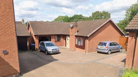 A Google Maps street view image of a bungalow. Two cars are parked outside.