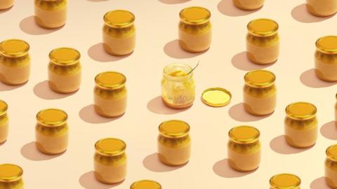 Several jars of honey on a beige background