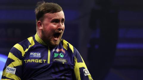 Luke Littler celebrates with his mouth wide open