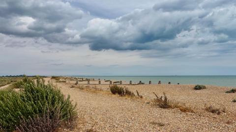 Cloudy and overcast sky over a shingle beach 