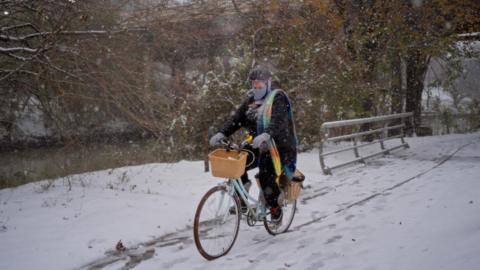 A cyclist encounters roads covered in snow in Houston, Texas