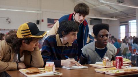 Still image from Stranger Things in which four boys are pictured in a school canteen