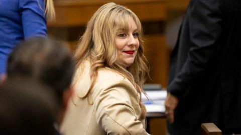 Abigail Zwerner in beige leather jacket in court