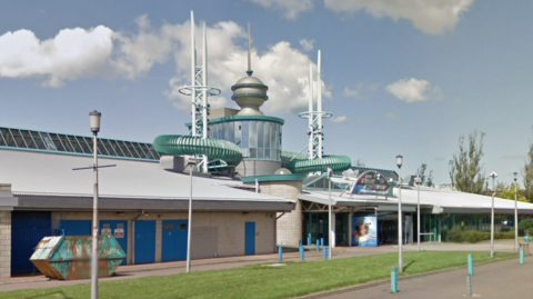 A large leisure centre building, with beige brickwork.
