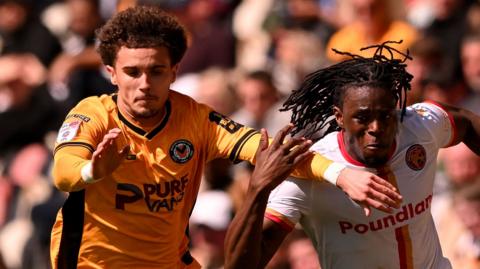 Josh Martin of Newport County battles for the ball with Nathan Asiimwe of Walsall