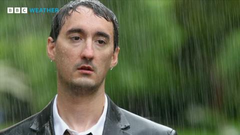 A man in a suit is drenched in the pouring rain