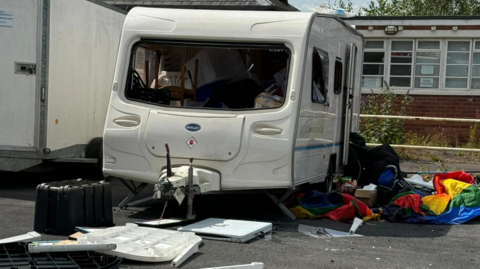 Pride caravan with windows smashed and contents strewn around the floor