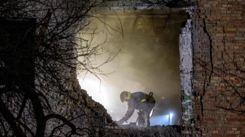 An emergency responder works at the site of an apartment building that was hit during a Russian missile and drone attack on Kyiv on 29 November 2025.