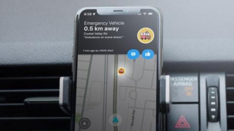 Close up shot of a phone using new digital system showing an emergency vehicle is 0.5 km away