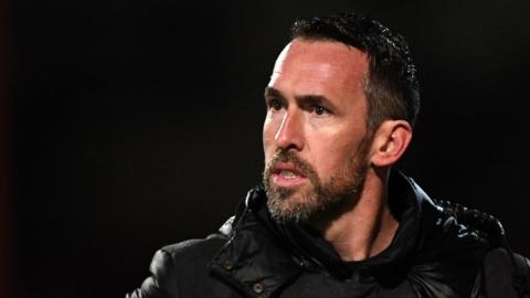 Christian Fuchs dressed in black jacket with concerned look