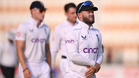 Ben Duckett holds his left hand after taking a blow while taking a catch