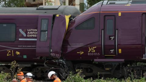 The ends of two damaged purple trains which have crashed together. 
