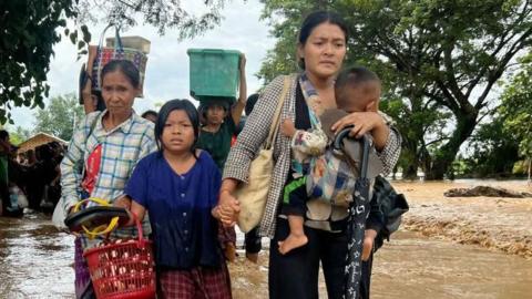 Residents walk through flood waters in Pyinmana in Myanmar's Naypyidaw region on September 13, 2024,