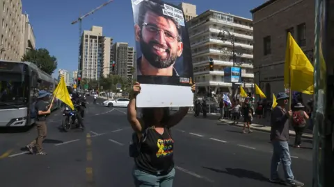 Demonstrators lift placards and chant slogans during an anti-government protest calling for the release of Israelis held hostage by Palestinian militants in Gaza since October, in central Jerusalem 