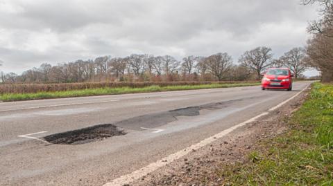 A pothole on a fast rural road in the UK.