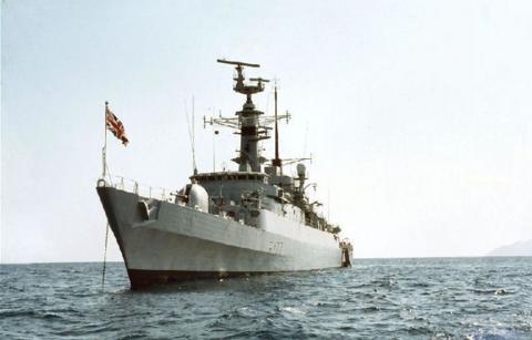 HMS Ambuscade sailing on water with flag raised