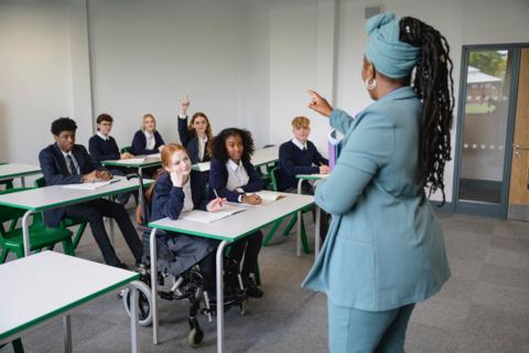 A teacher in a classroom working with a number of pupils