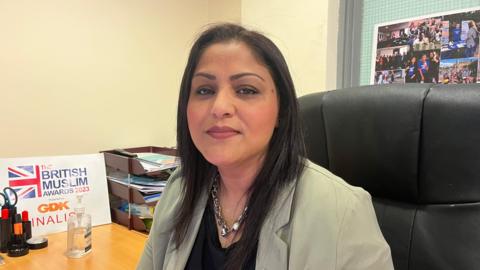 Humma Nizami, executive director at the Race Equality Network in Bradford at her desk