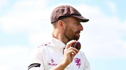 Jack Leach holds the ball up as he leaves the field having taken five wickets