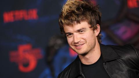 Joe Keery in leather jacket at Stranger Things premiere