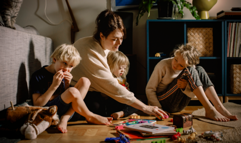 Woman and her three children playing