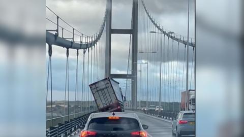 View looking down the Humber Bridge, where a high-sided vehicle is tipping over to the left