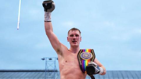 Jack Massey poses for a photo with the title belts after victory over Isaac Chamberlain 