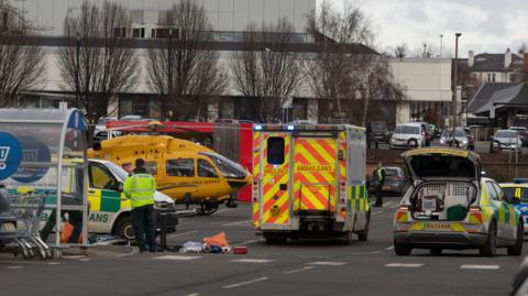 An air ambulance, ambulance and emergency service presence in a Tesco car park.