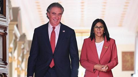 Venezuela's interim president, Delcy Rodriguez and US Interior Secretary Doug Burgum walk side by side