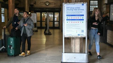 A sign (R) showing the status of train lines at St. James's Park underground, or Tube, station is pictured in central London