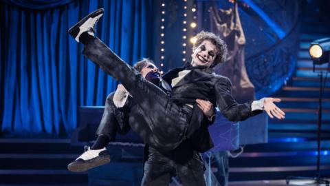 Katya Jones holds Lewis Cope aloft as part of their couple's choice performance.