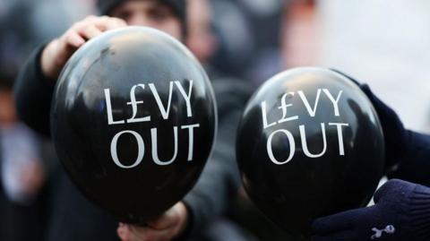 A group of Tottenham fans protesting against chairman Daniel Levy in December 2024