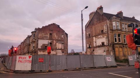 Derelict buildings in Pollokshields, with boarding around it