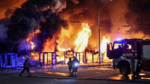 Firefighters work at a site of a book market hit by a Russian missile strike