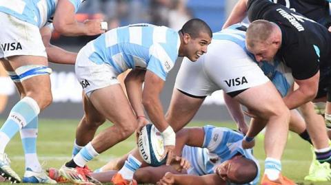 Scrum-half Simón Benítez Cruz passes the ball away from a ruck for Argentina.
