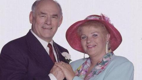 The actor Tony Caunter playing Roy Evans in a smart wedding suit next to Pam St Clement as Pat Butcher at their wedding in EastEnders 