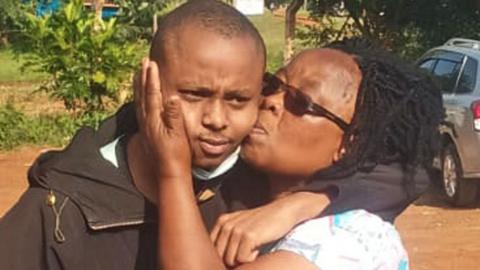 Billy Mwangi frowns slightly as he is kissed by his mother after he was freed following his abduction 