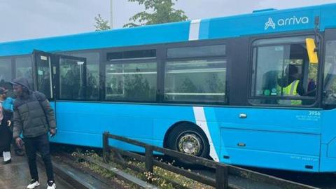 A bright blue bus partially mounted on a walkway.