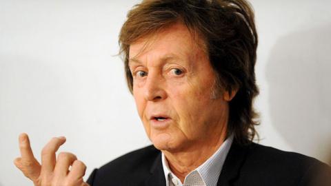 Headshot of musician Paul McCartney, wearing black blazer and open-necked shirt, taken in 2014