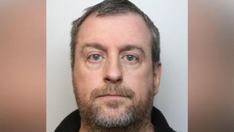Police head and shoulders image of Young, who has short greying hair and a brown/grey beard.