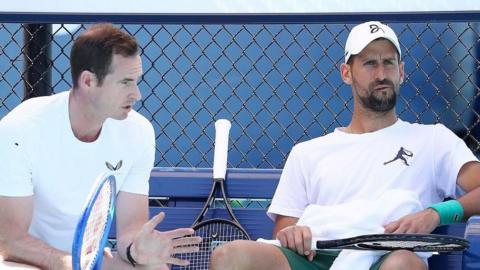 Andy Murray and Novak Djokovic speak to each other during a practice session at the Australian Open