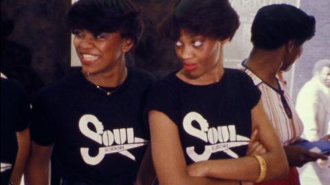 Two women in Soul Scissors t-shirts at a new salon for Black hair.